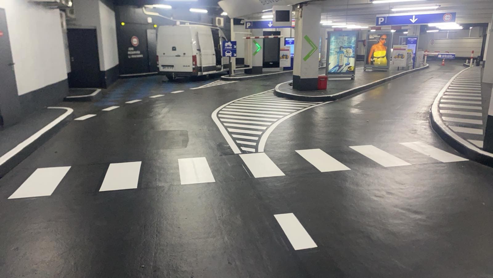 Niveau de parking souterrain au marquage neuf : passages piétons et zébras blancs